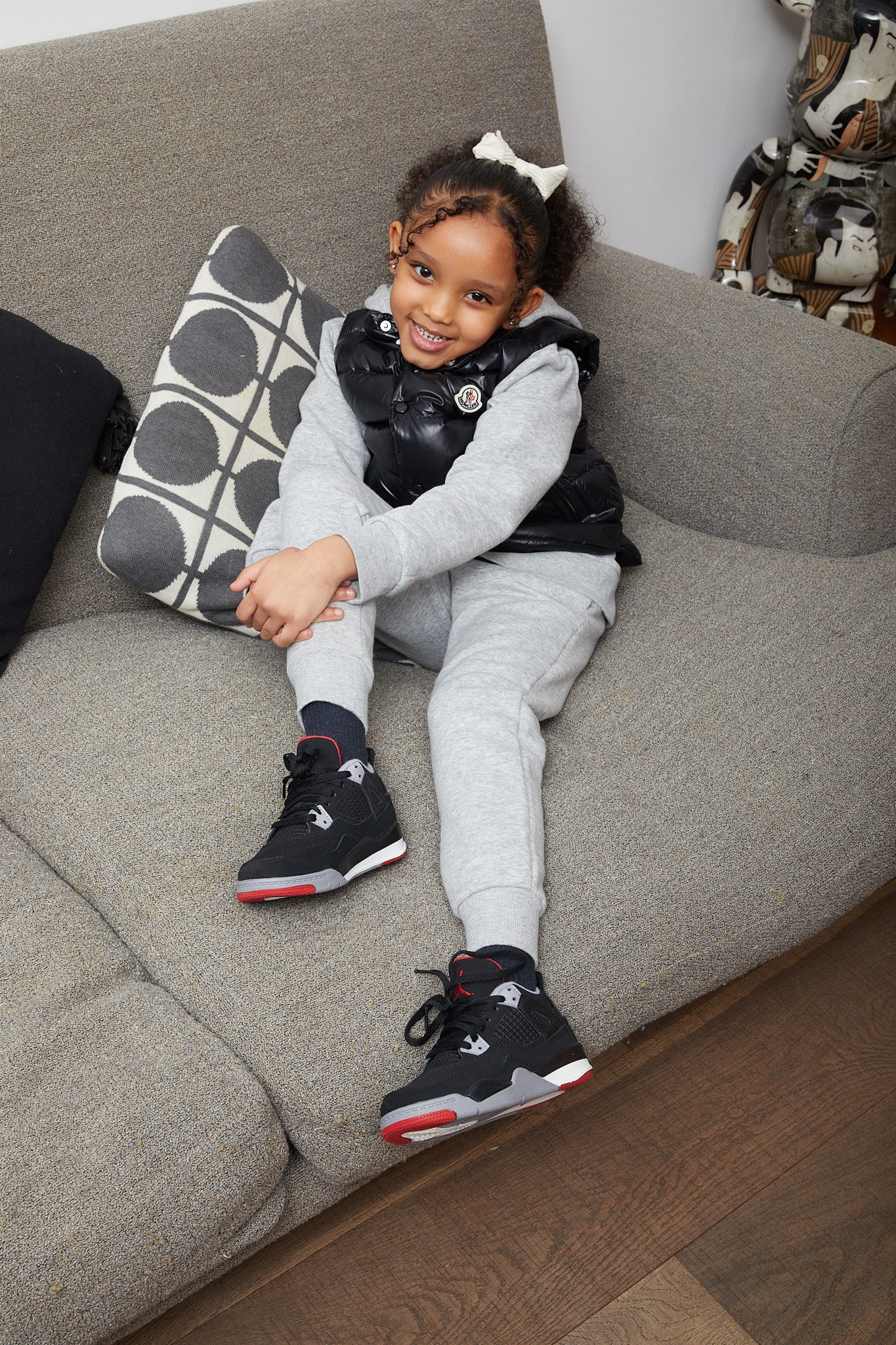 little girl wearing Air Jordan 4 Kids 'Bred'