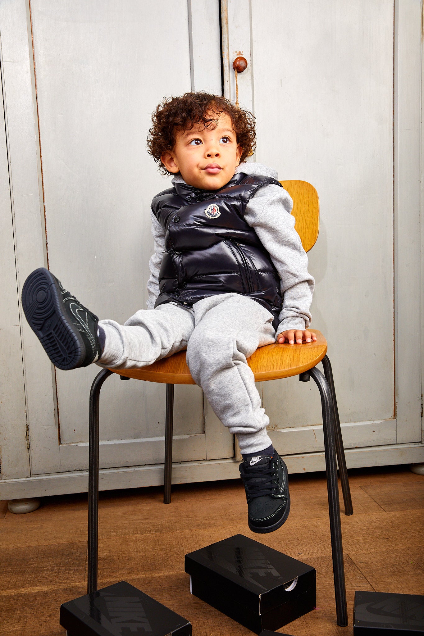 little boy wearing Air Jordan 1 Low x Travis Scott Kids 'Black Phantom']