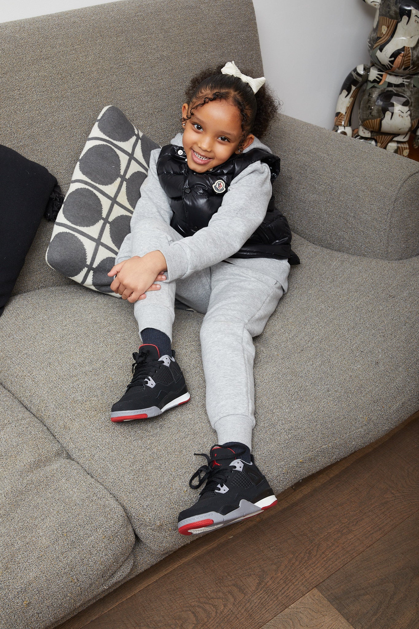little girl wearing Air Jordan 4 Kids 'Bred'